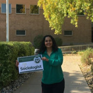 Monica holding "I'm a Sociologist" sign
