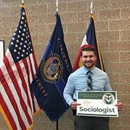 Teagan holding "I'm a Sociologist" sign